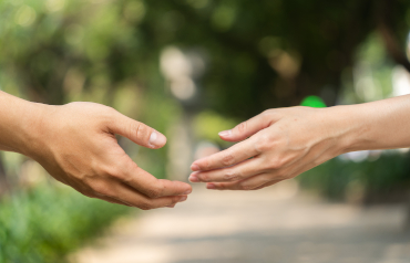 Ein Mann und eine Frau strecken sich die Hand entgegen – Annäherung durch Blog Eheberatung und Paartherapie Paderborn