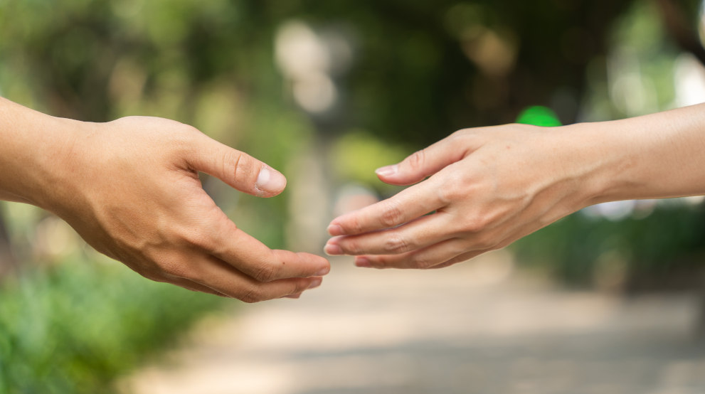 Ein Mann und eine Frau strecken sich die Hand entgegen - Eheberatung und Paartherapie Paderborn mindern Ihre Leiden!