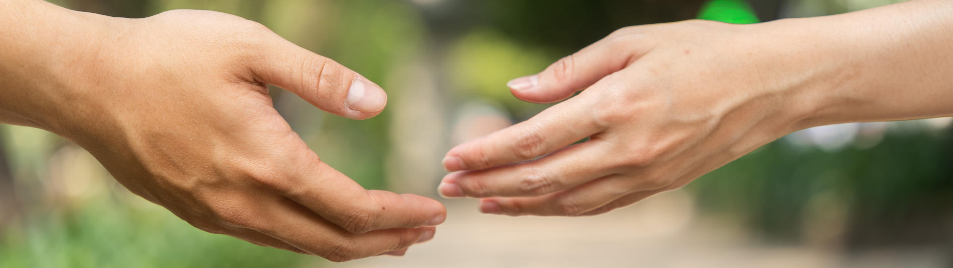 Ein Mann und eine Frau strecken sich die Hand entgegen - Eheberatung und Paartherapie Paderborn mindern Leiden!