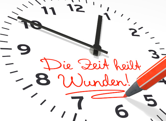 Uhr mit roter Aufschrift: Die Zeit heilt Wunden!