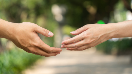 Ein Mann und eine Frau strecken sich die Hand entgegen – Annäherung durch Blog Eheberatung und Paartherapie Paderborn
