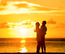 Wir wollen wieder ein Paar werden! Ein Liebespaar bei aufgehender Sonne am Strand.