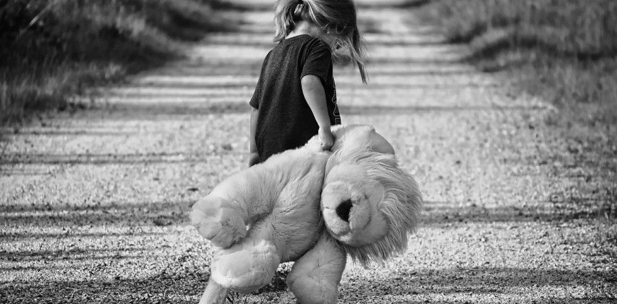 Ein Mädchen zieht traurig Ihren Teddy hinter sich her - Depression im Kindesalter