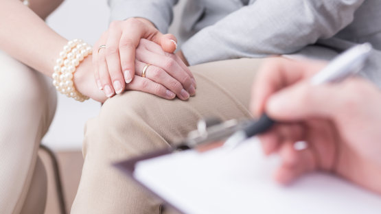 Ehepaar sitzt nebeneinander im Gespräch mit einem Berater – Eheberatung in Paderborn