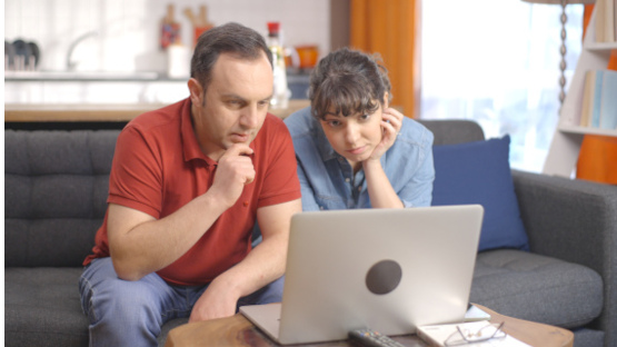 Ein Paar schaut zusammen gespannt auf einen Laptop - Paartherapie-Paderborn